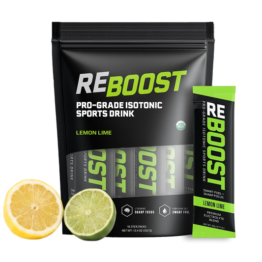 A stand-up pouch of REBOOST Pro-Grade Isotonic Sports Drink in Lemon Lime flavor, shown with a single stick pack and lemon and lime slices on a clean white background.