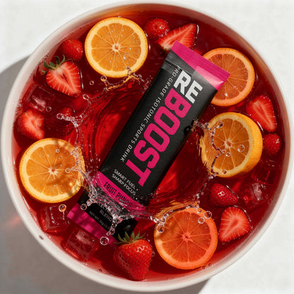 REBOOST fruit punch packet in a bowl of fruit punch with strawberries and oranges.