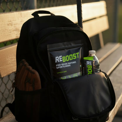 Black backpack with REBOOST sports drink and water bottle on a bench