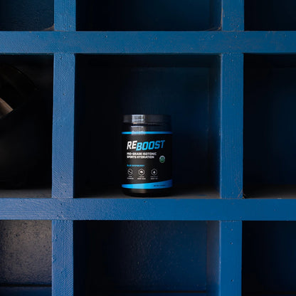 REBOOST hydration 1lb container on a blue grid shelf
