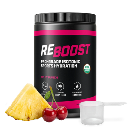 A black tub of REBOOST Pro-Grade Isotonic Sports Hydration in Fruit Punch flavor, shown on a white background with a pineapple slice, two red cherries, and a clear plastic scoop.